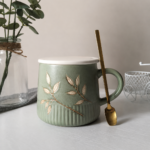 Premium sage green ceramic cup with botanical leaf design